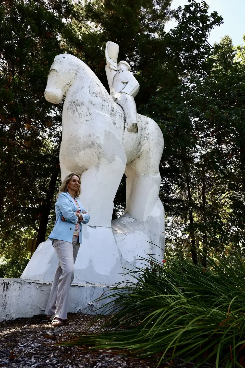 Jill Cuadros standing beside a white horse sculpture in Springfield